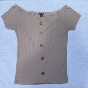 a sleeveless tan shirt with buttons doing down, pretty stretchy